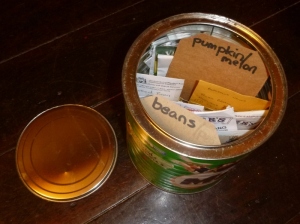 Seed tin for large seeds, stored inside paper packets.